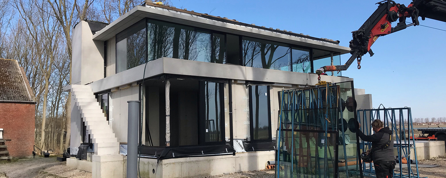 Plaatsing van aluminium ramen door Ramaco ramen en deuren in Eeklo met kraan in een modern nieuwbouwproject