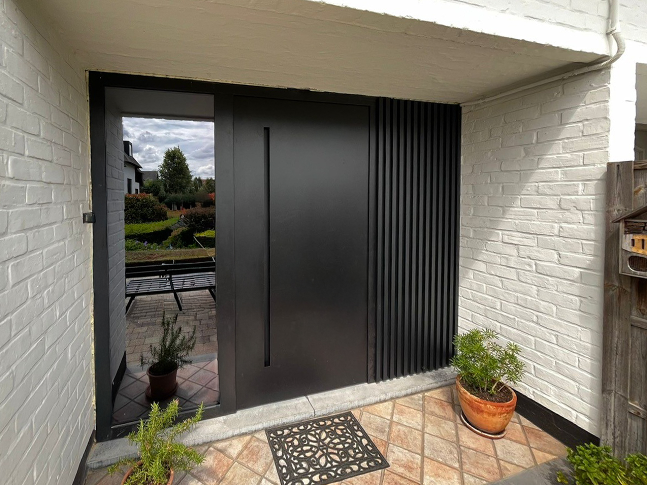 Aluminium voordeur met zijraam en verticale gevelprofielen – strak design en perfecte afwerking door Ramaco