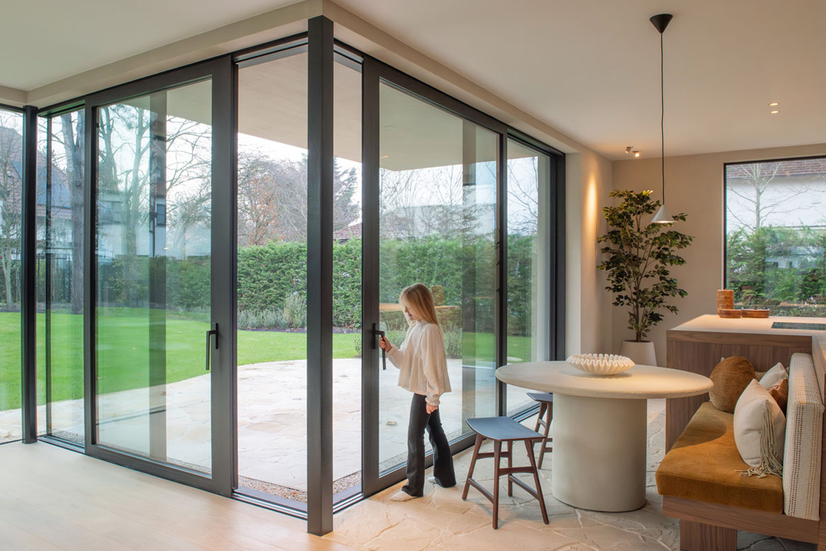 Aluminium hoekschuifraam met slanke profielen en zicht op tuin, geplaatst door Ramaco